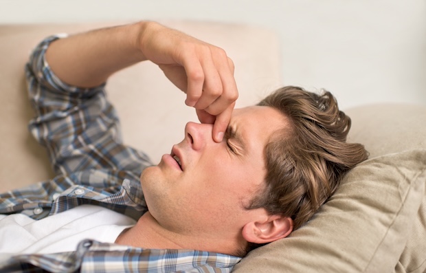Man holding nose due to nasal congestion