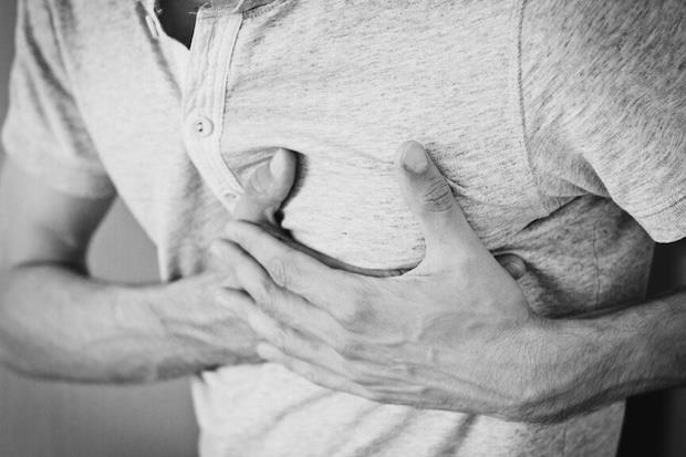 Man holding chest due to shortness of breath