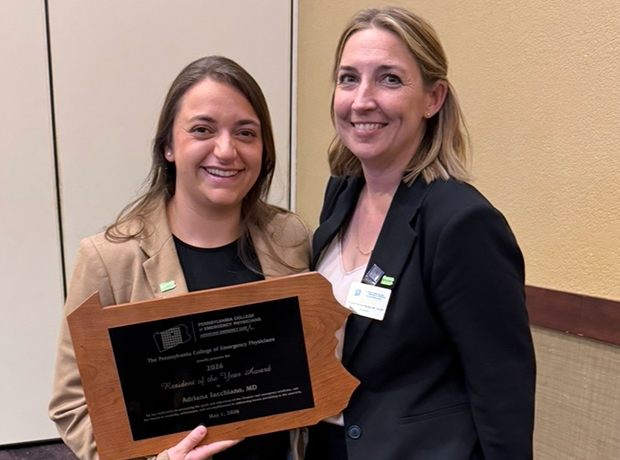 two people standing with an award