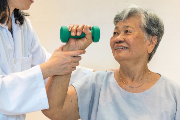 Medical Professional helping a patient with a weight in her hand