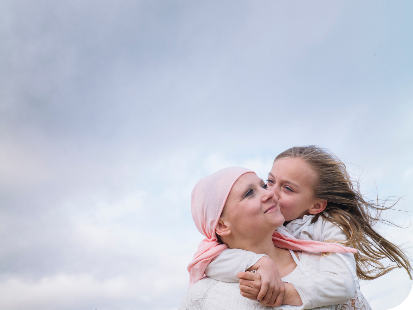 Young child hugging and kissing her mother