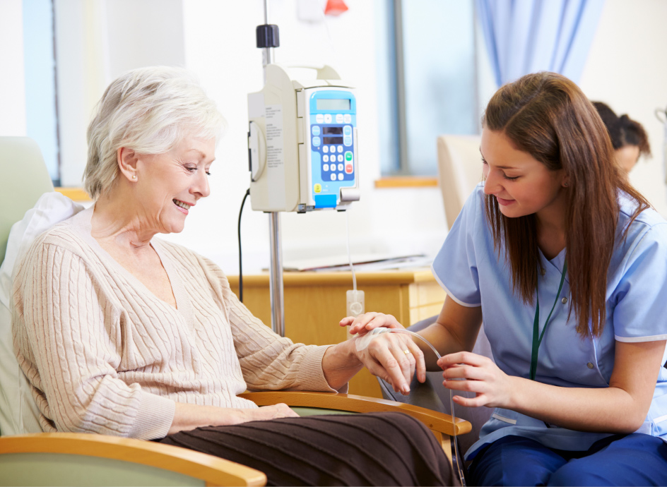 Medical Professional sitting with a cancer patient receiving treatment