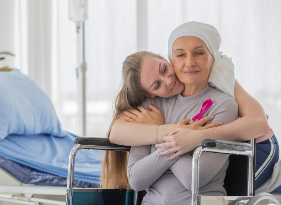 Caretaker hugging a cancer patient in a wheelchair