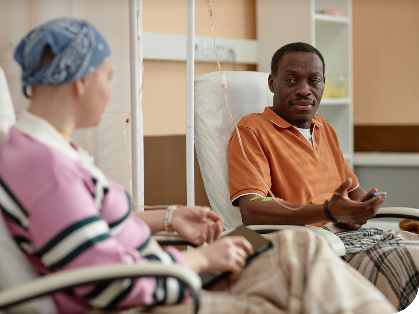Two cancer patients sitting near each other receiving treatments