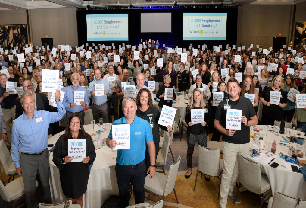 Employees holding a 20,000 and counting signs