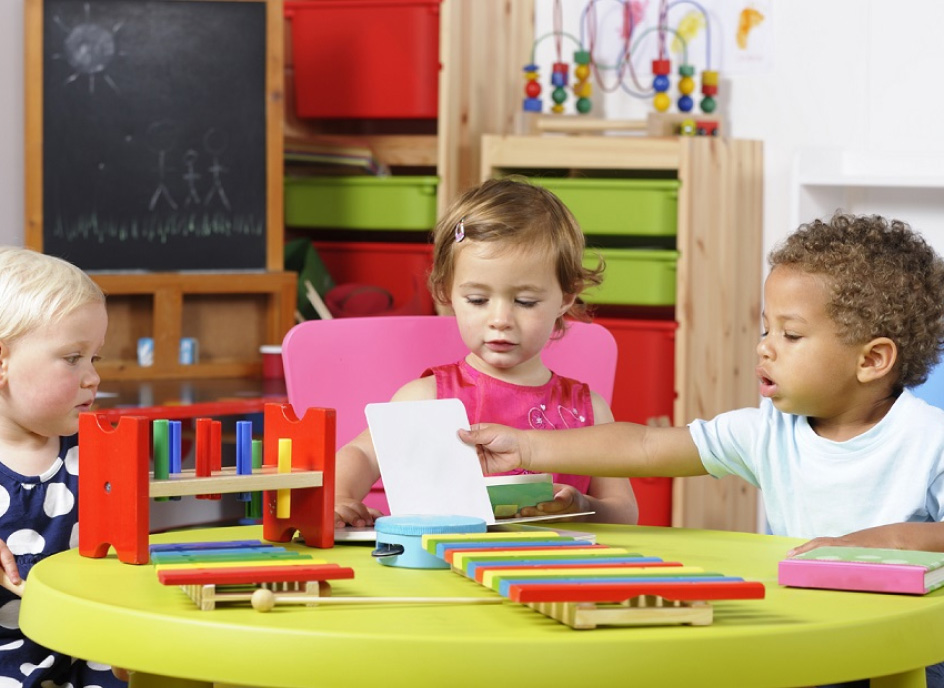 Nursery school children playing around a table