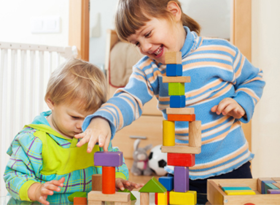 Two toddlers playing with blocks
