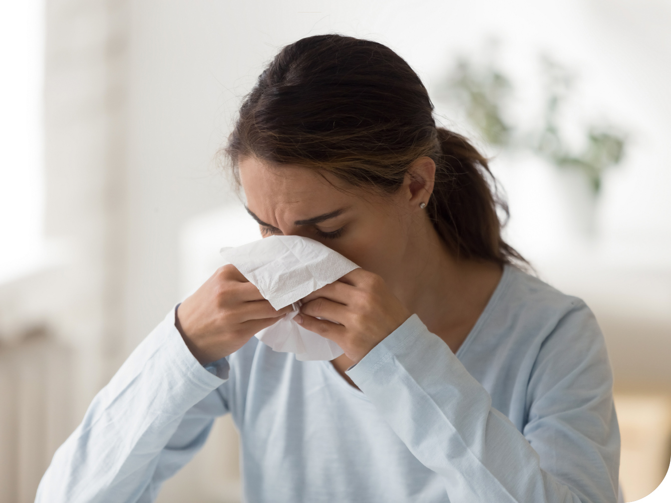 Young woman blowing her nose