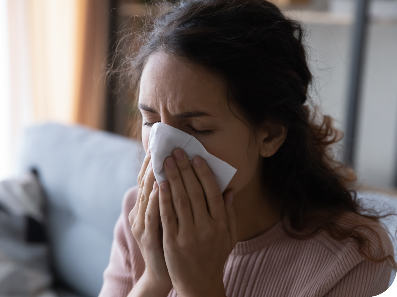 Young woman blowing her nose