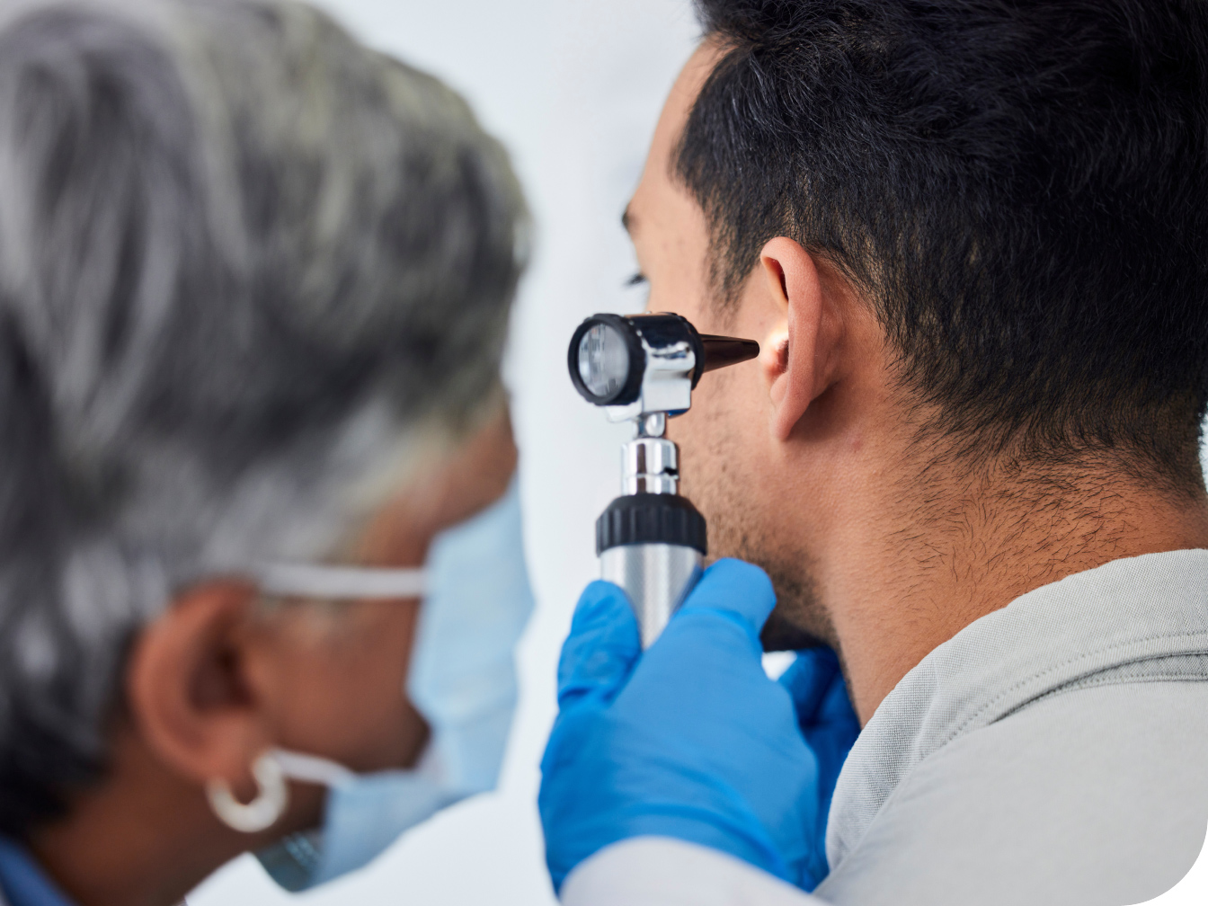Medical professional looking into a patient's ear