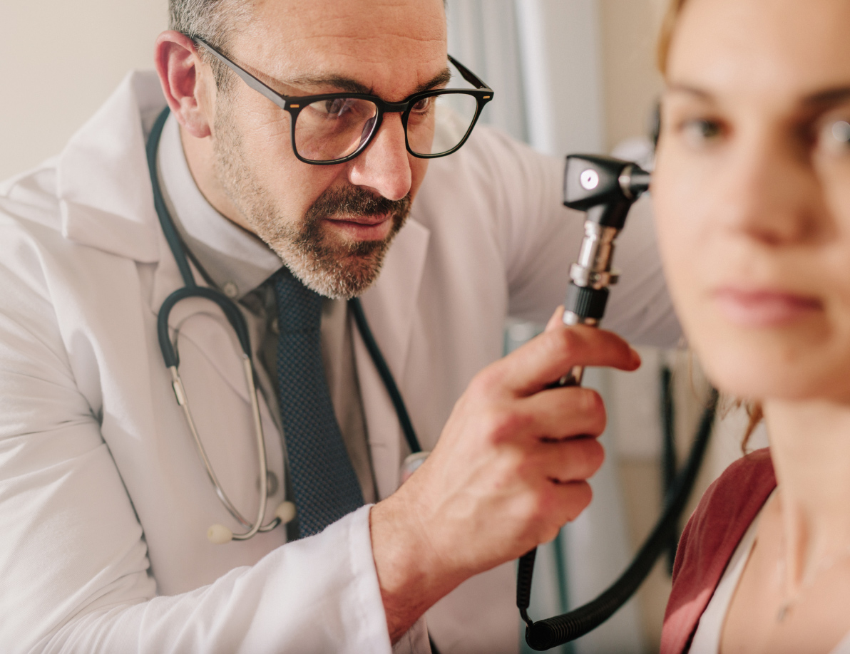 Medical professional looking into a patient's ear