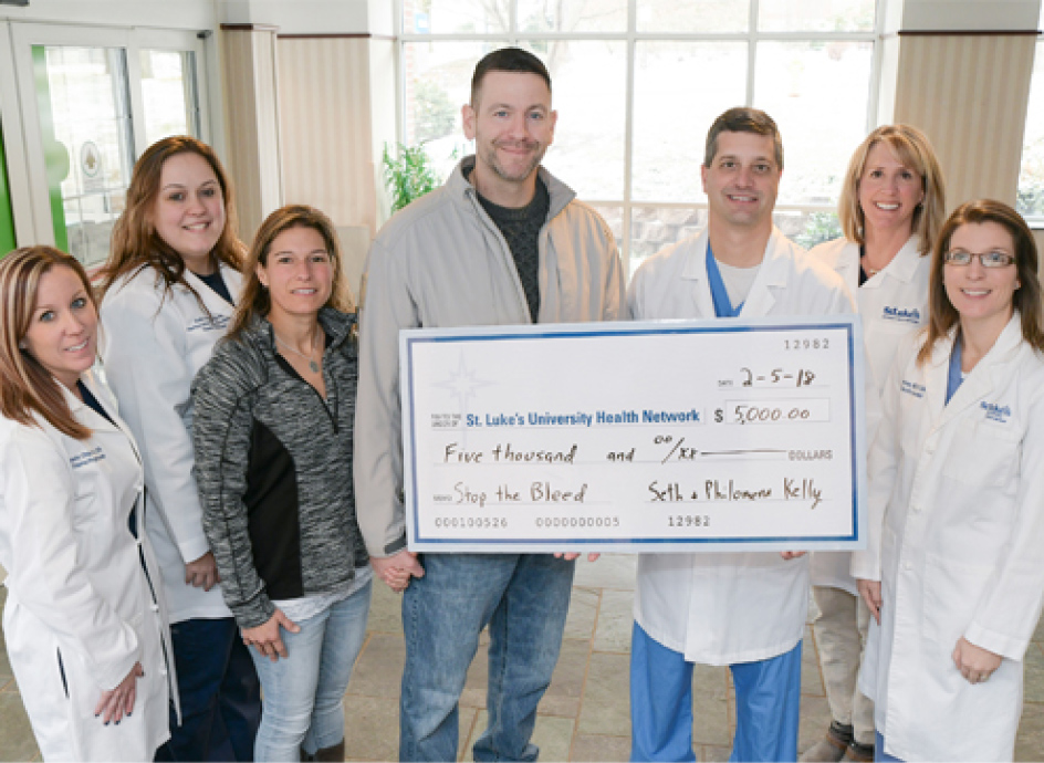 Group of medical professionals holding a large check