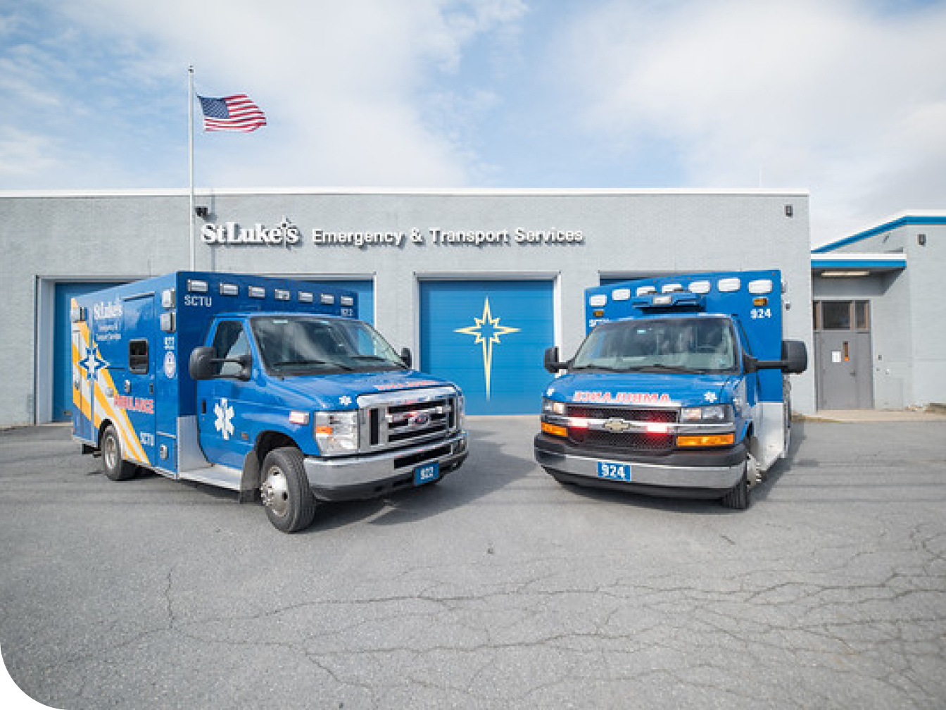 Two ambulance vehicles parked outside a St. Luke's facility