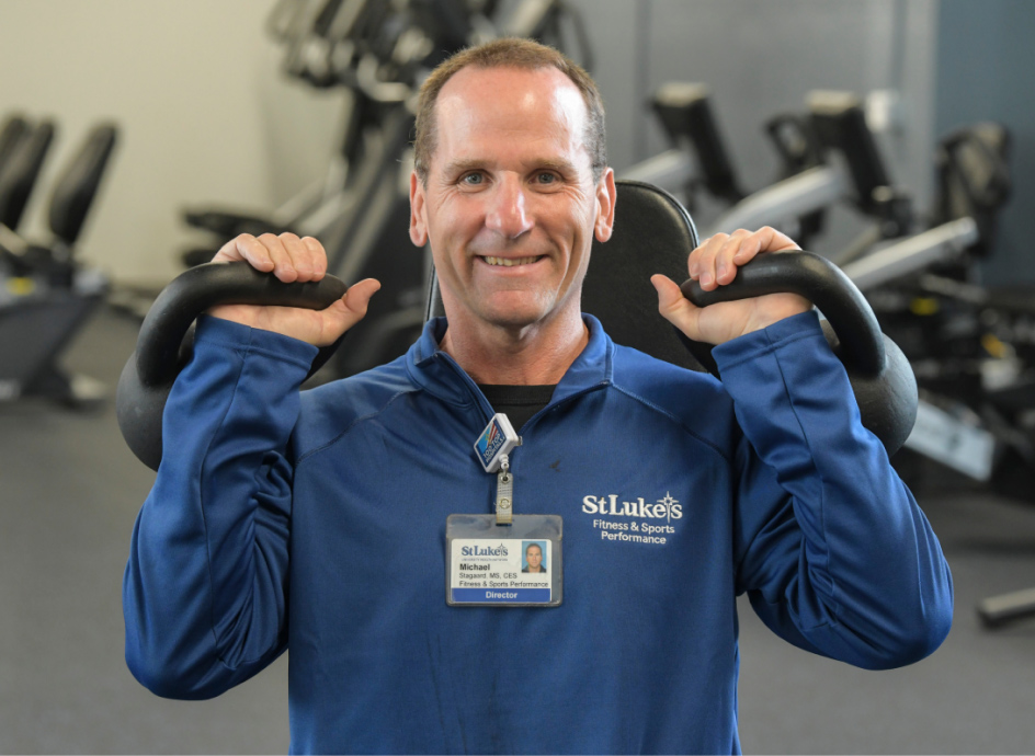 Gym instructor lifting two kettlebells
