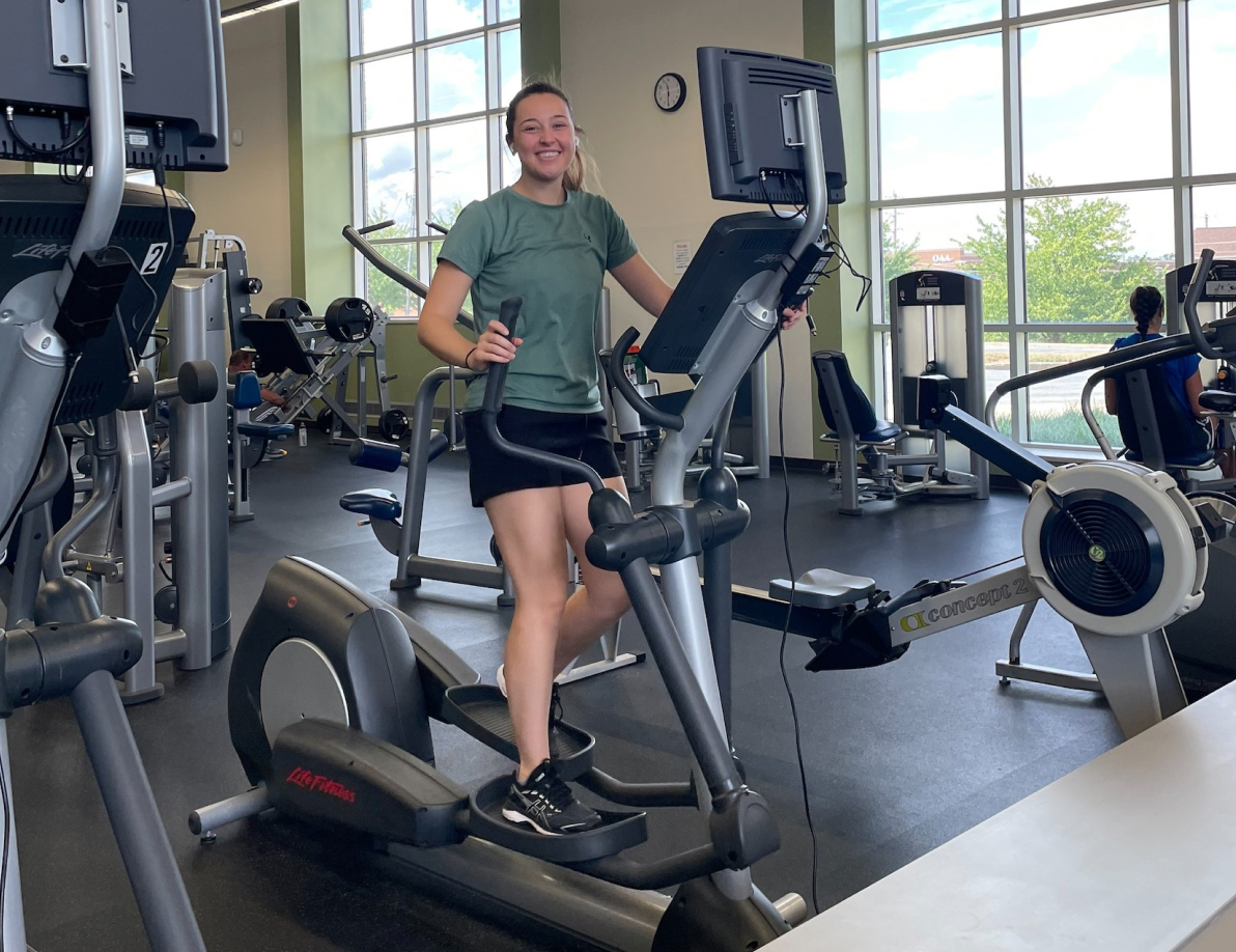 Gym member on an elliptical machine