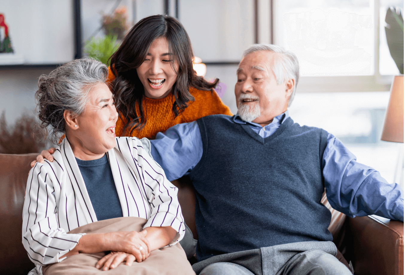 Caretaker with elderly couple sitting on a couch