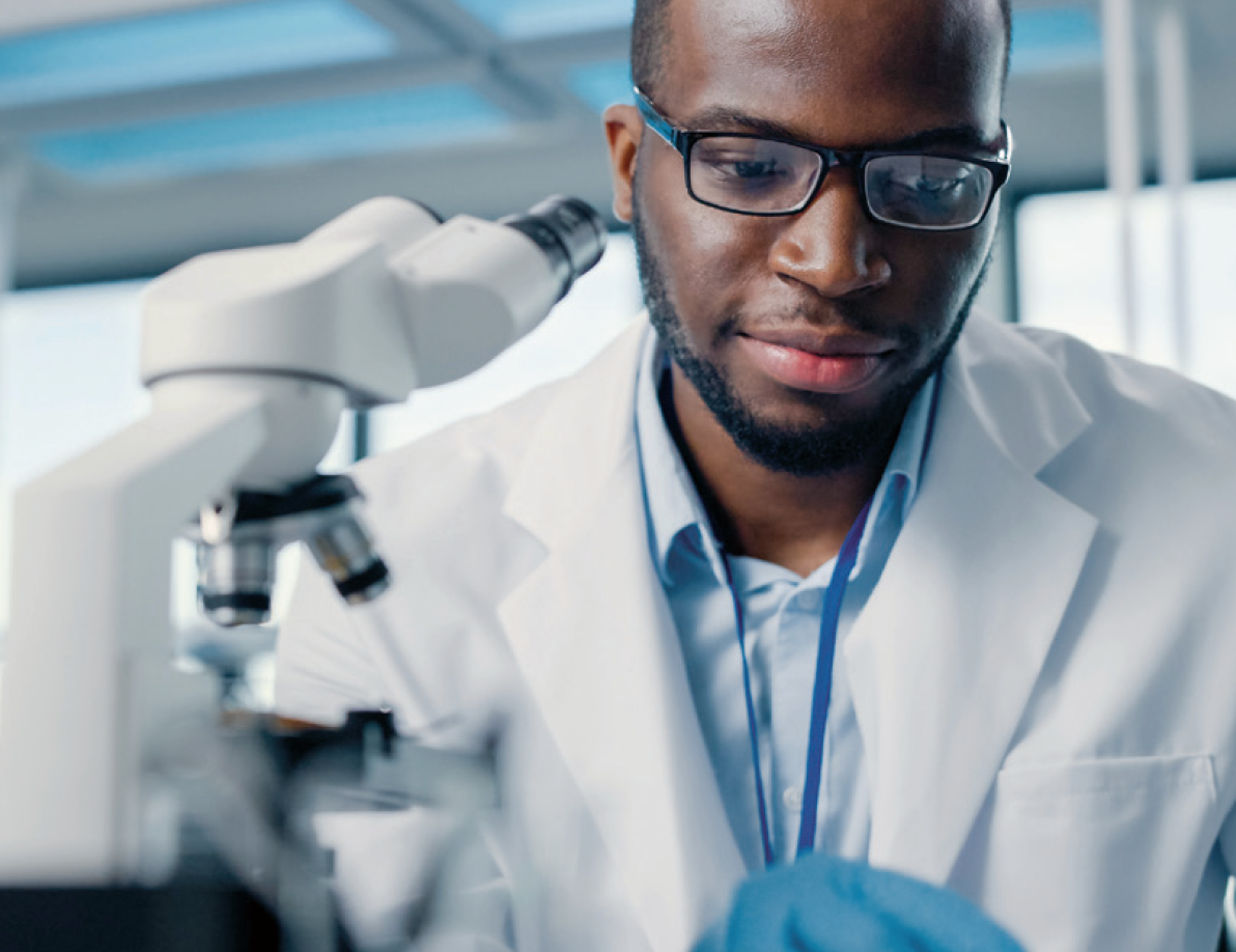 Scientist next to a microscope 