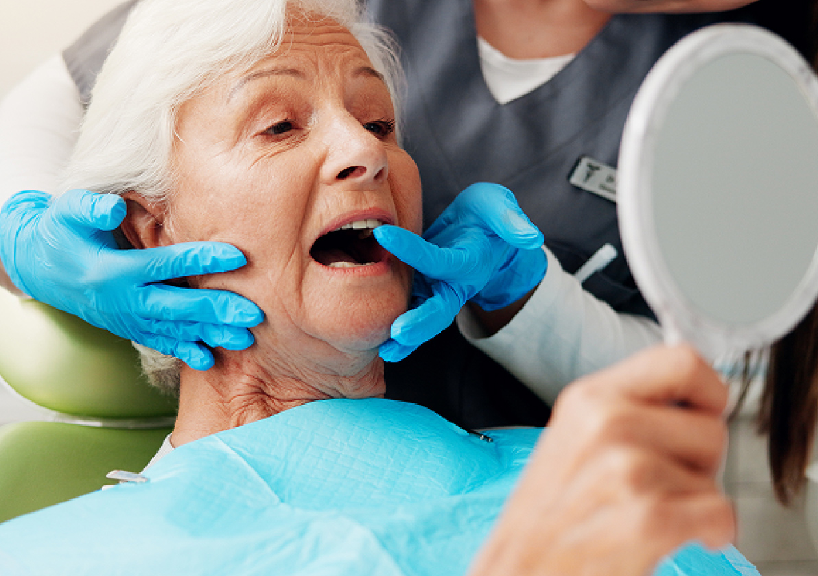 Patient looking in a mirror at her teeth