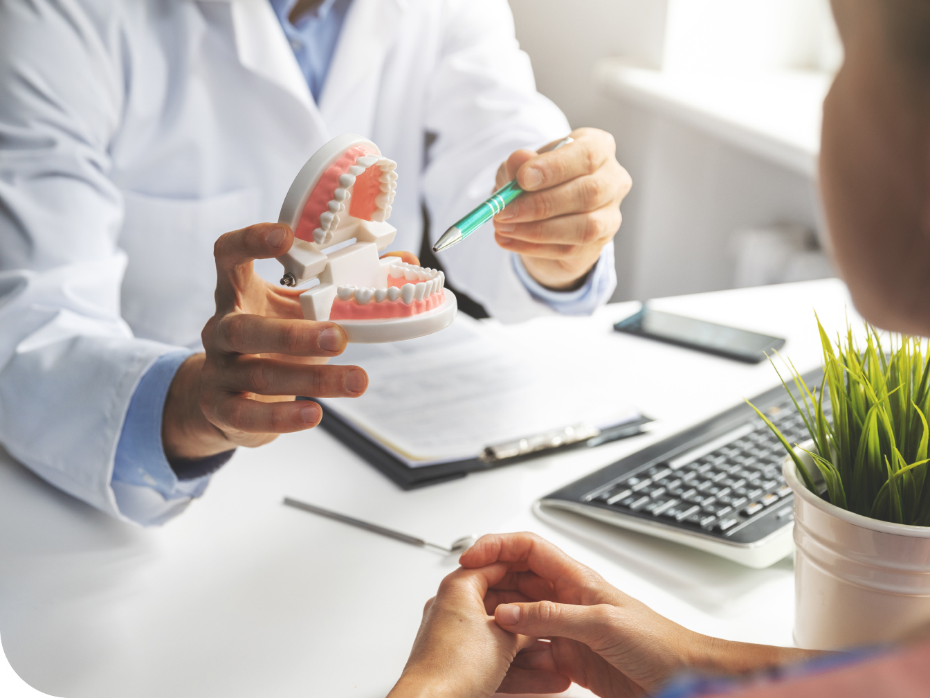 Dentist talking with patient at a desk