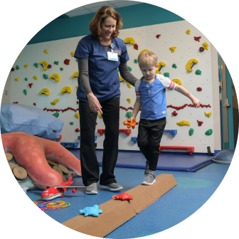 Physical Therapist helping a young child on balance beam