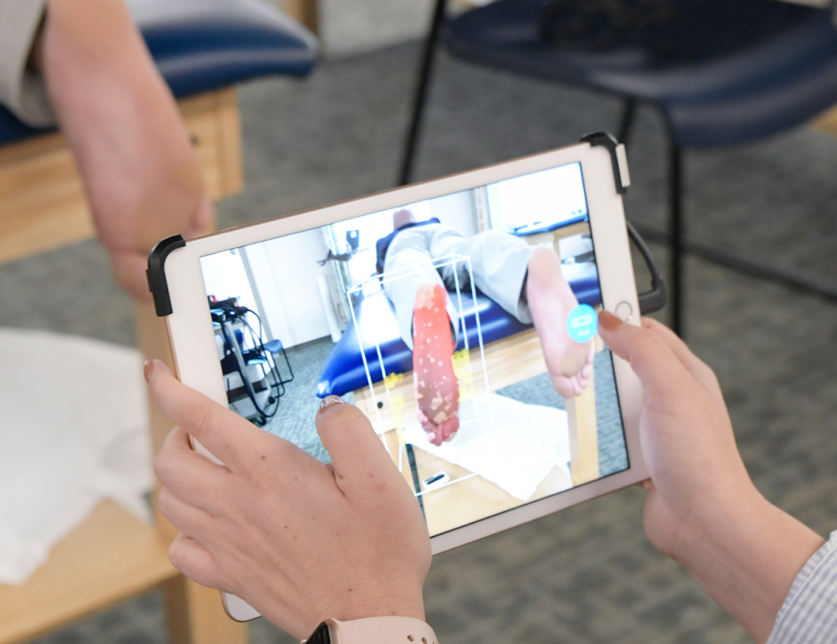 Physical Therapist viewing a tablet device