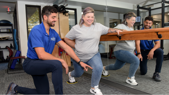 Physical therapist helping patient stretch