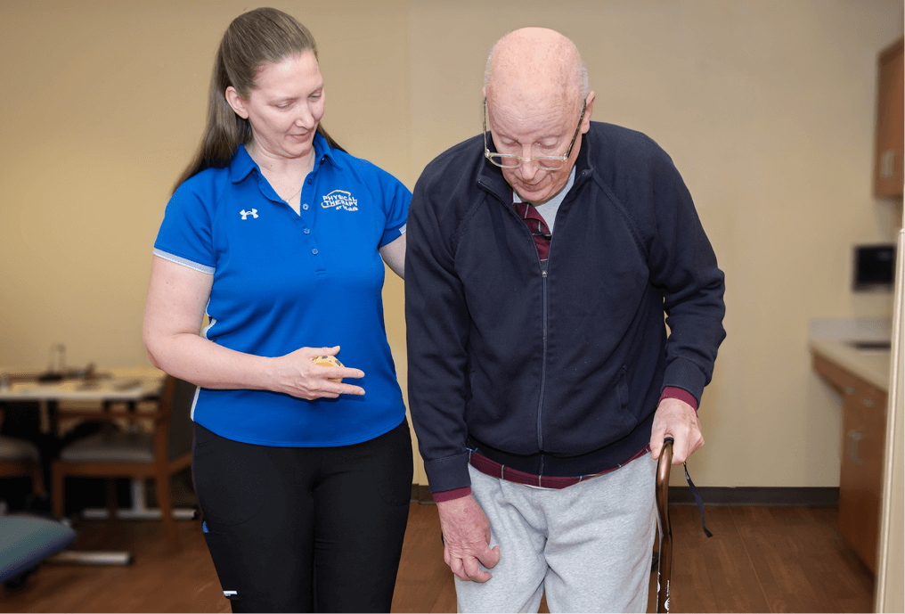 Physical Therapist helping patient walk down stairs