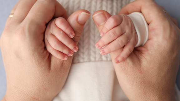 Parent holding baby hands