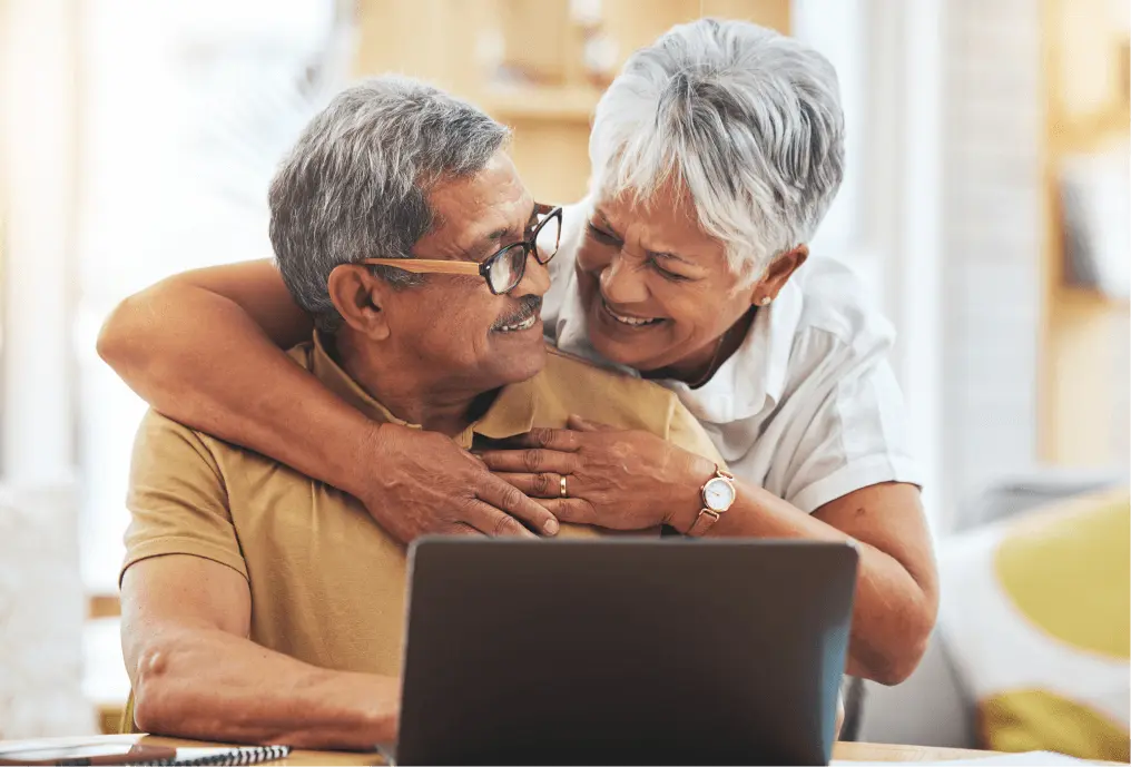 Couple laughing in front of laptop