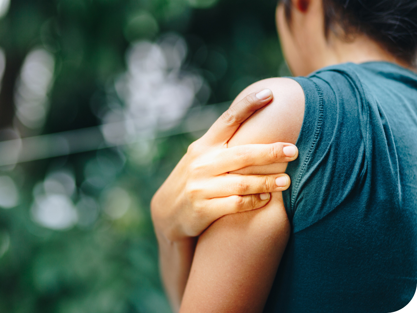 Individual holding shoulder with their hand