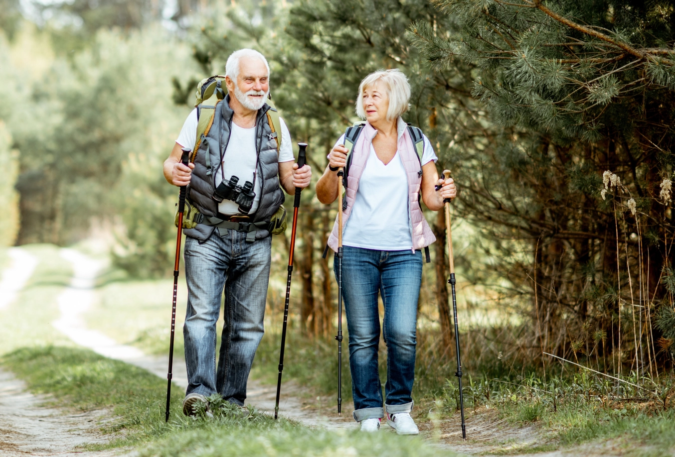 Elderly adult couple hiking on a trail