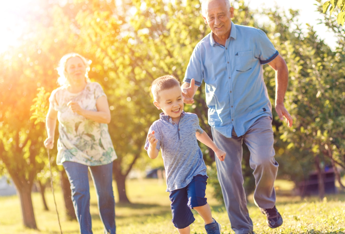 Grandparents chasing after grandson at the park