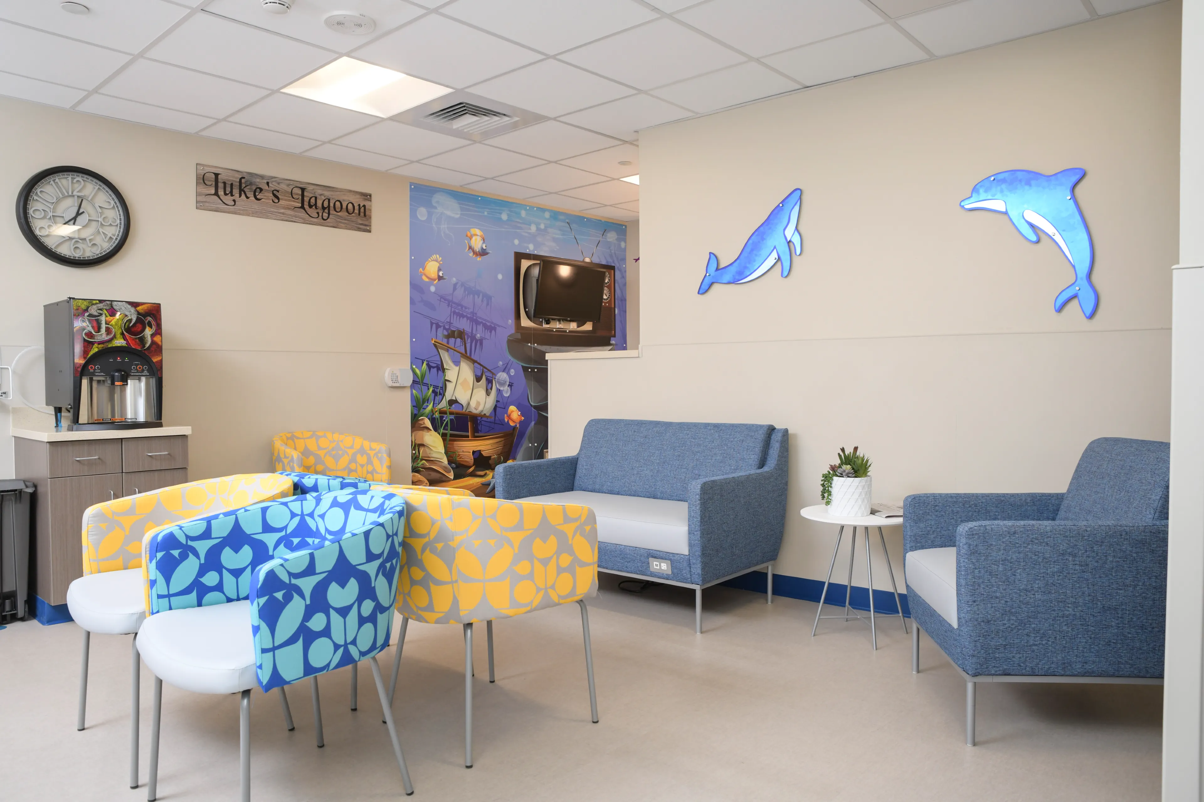 Hospital waiting room with colorful chairs and an industrial coffee machine