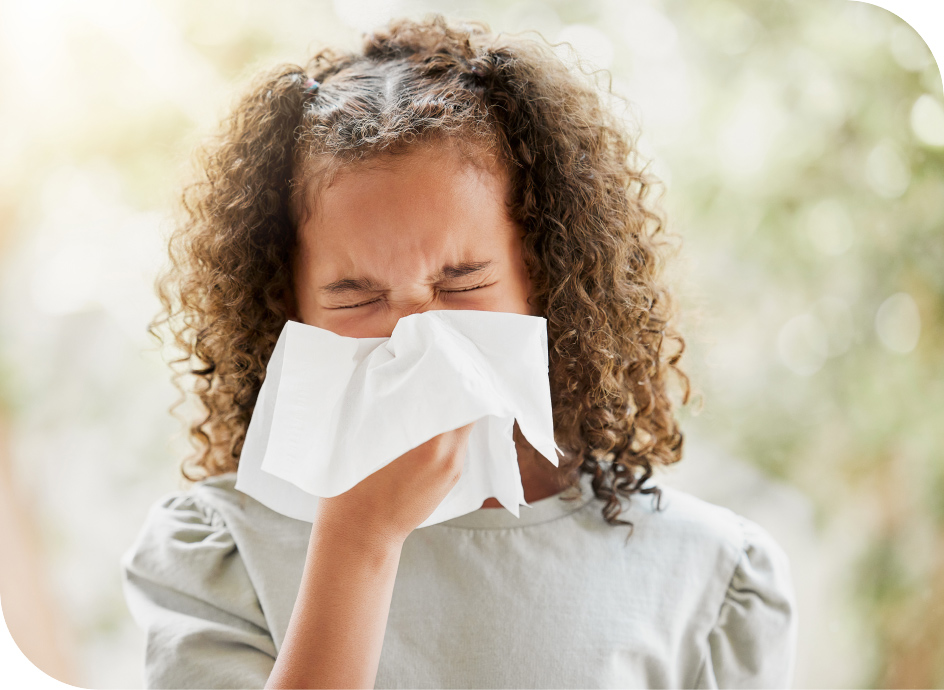Young girl with a tissue blowing her nose