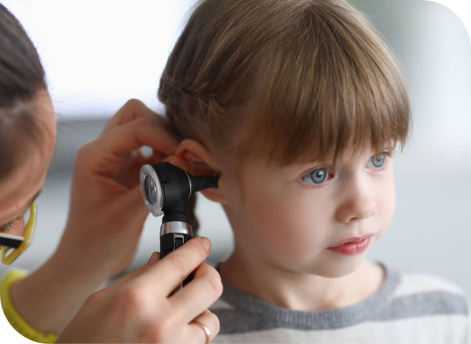 Medical professional looking inside a young child's ear