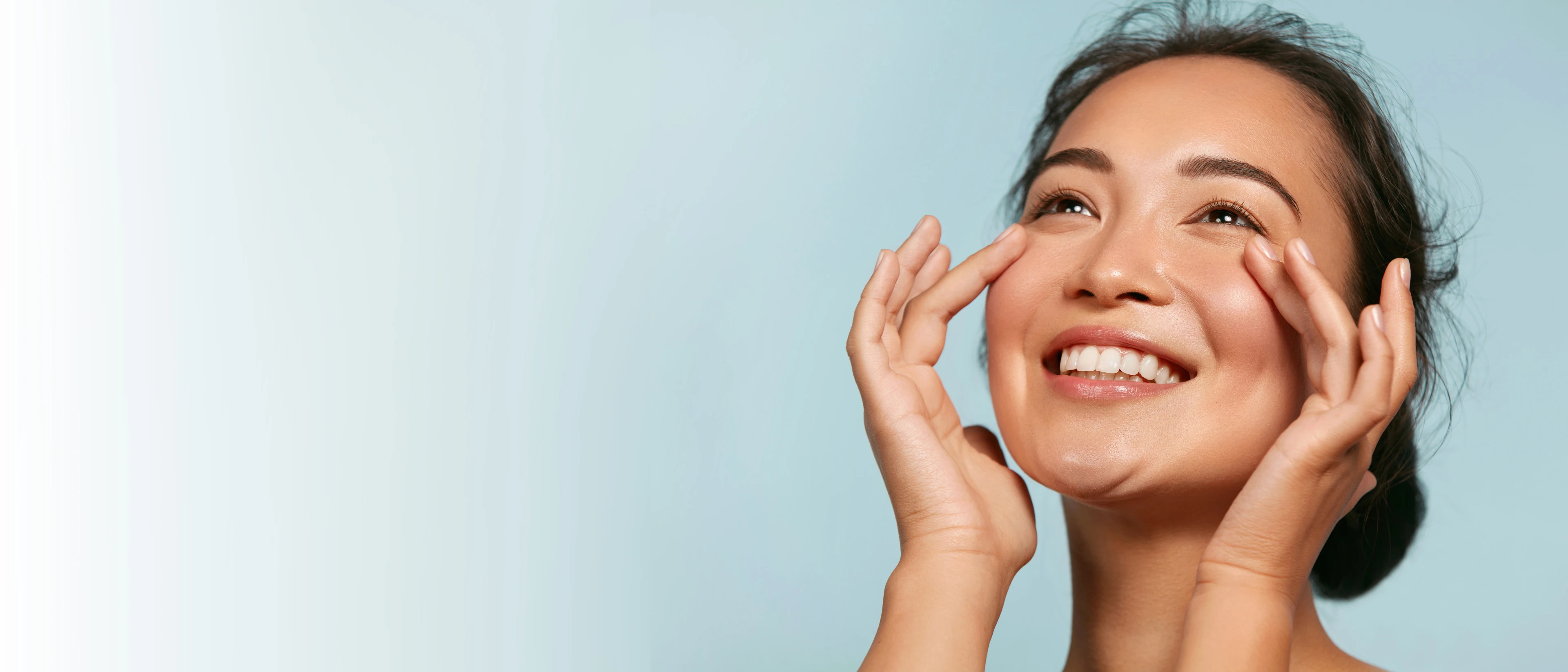 Close up of woman smiling while touching her fingers under her eye area