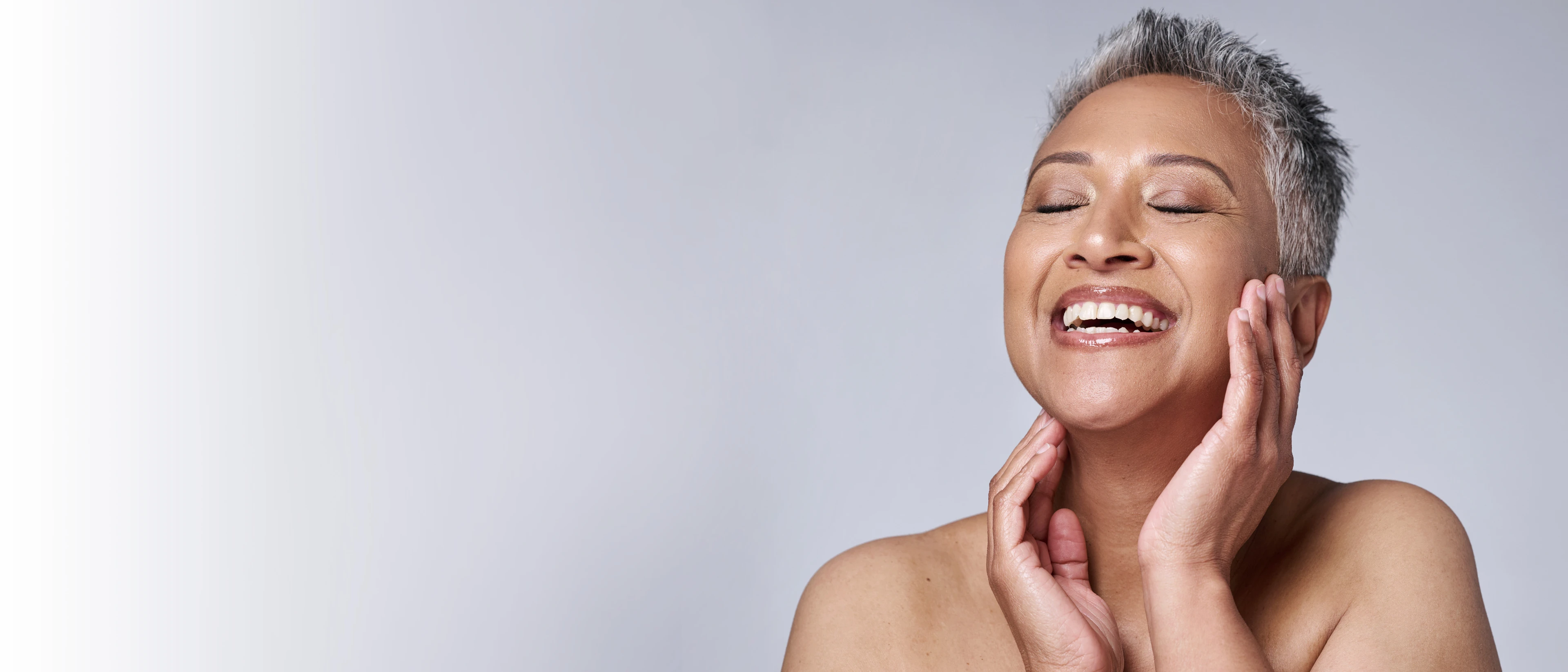 Close up of vibrant, older woman laughing with her eyes closed 