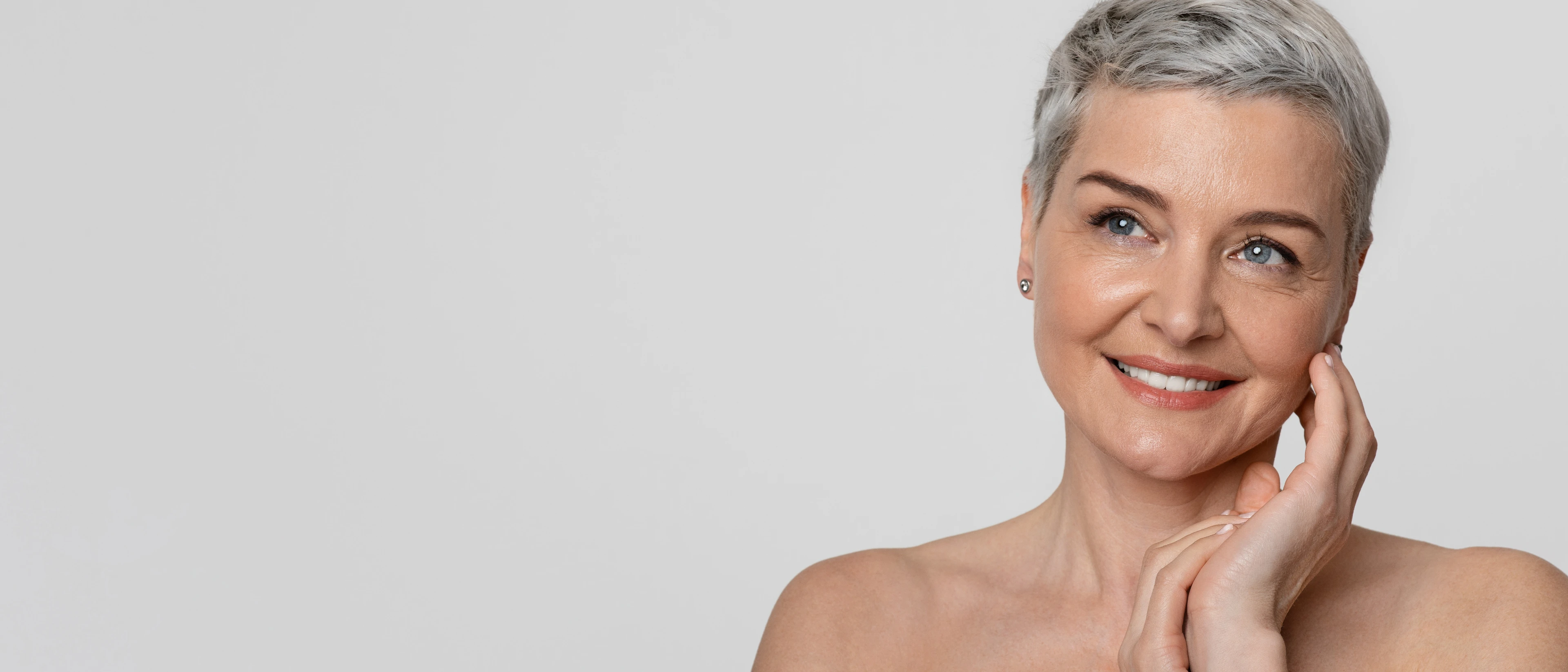 Close up of beautiful woman with grey hair touching her face