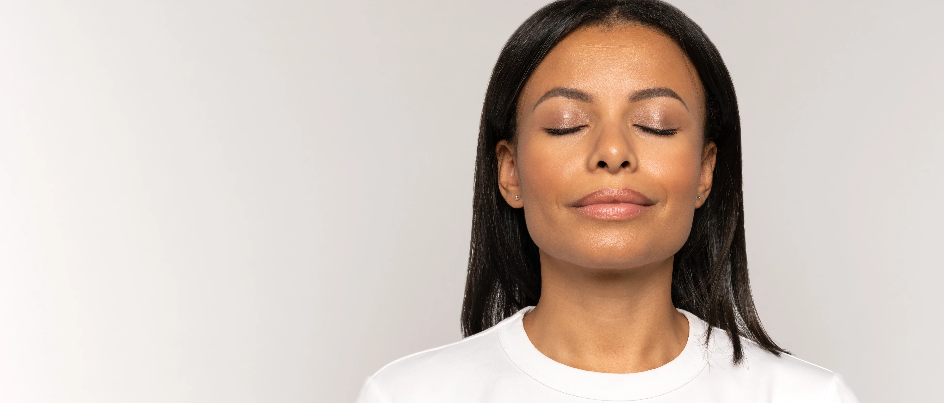 Woman's face with a soft smile and her eyes closed 