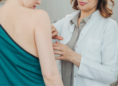 Medical Professional performing a breast exam on a patient
