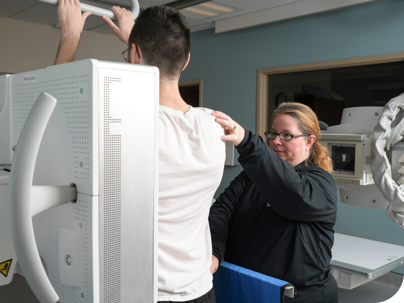 Medical Professional assiting a patient taking an x-ray