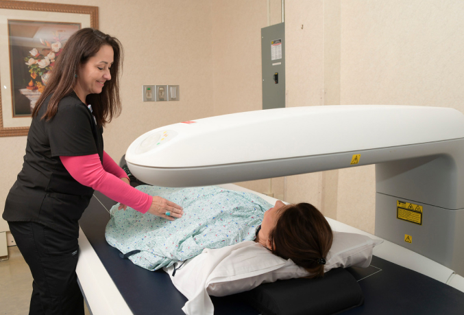 Medical Professional assisting a patient with a DEXA scan