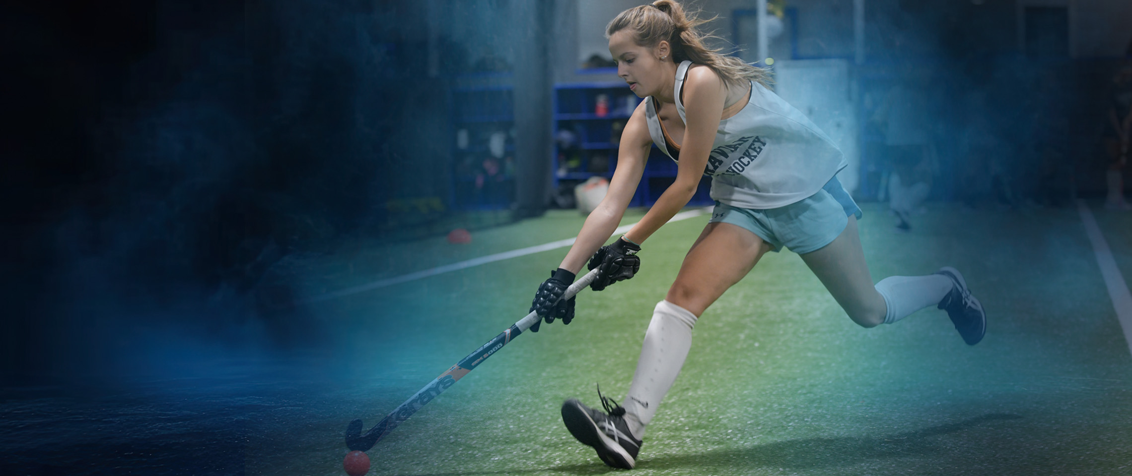 Young athlete running down an indoor field