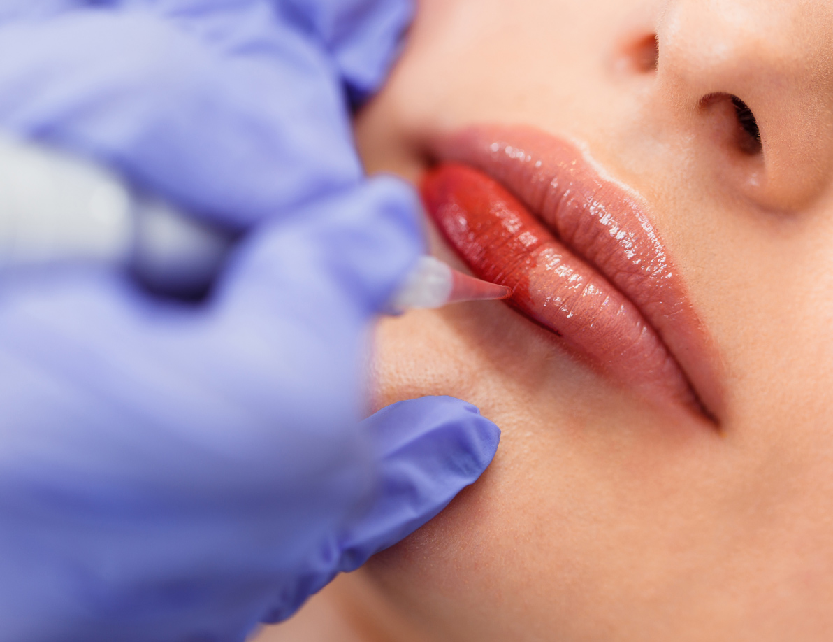 Professional applying permanent lip blushing to an individual