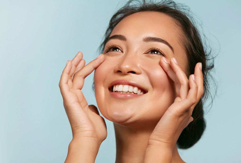 Woman smiling while touching her face