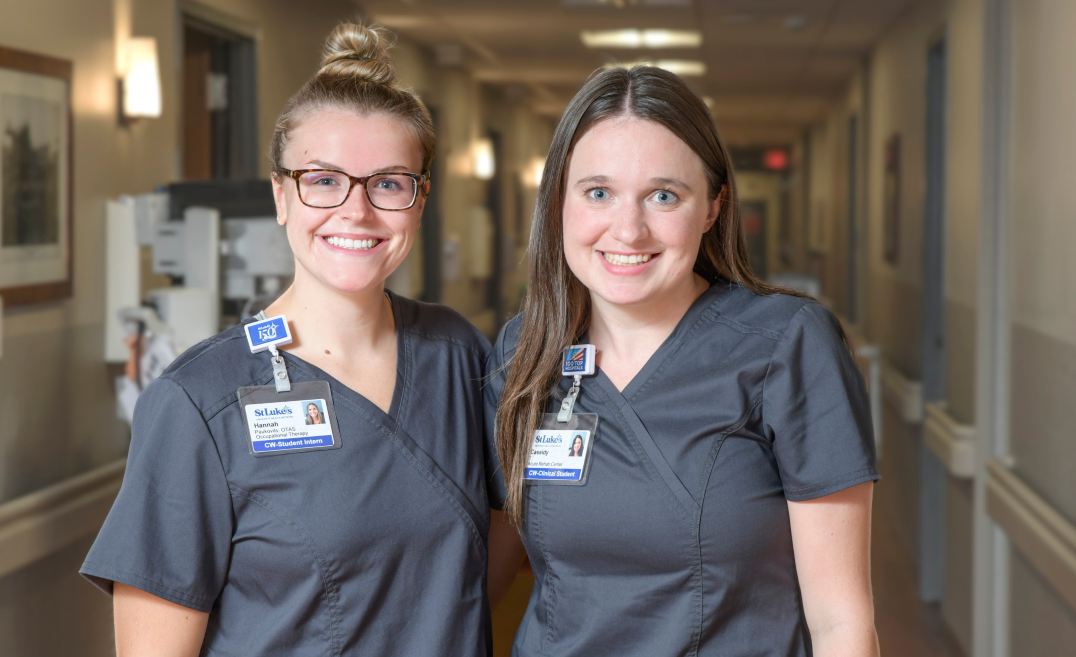 2 female health professionals inside hospital hallway