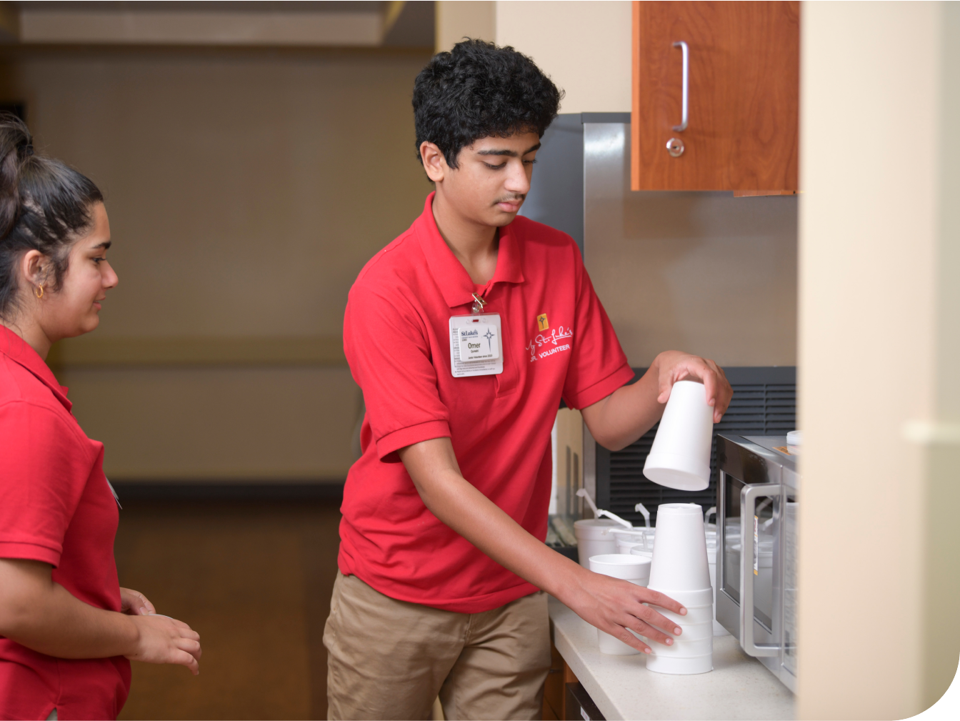 Junior volunteers filling cups of water