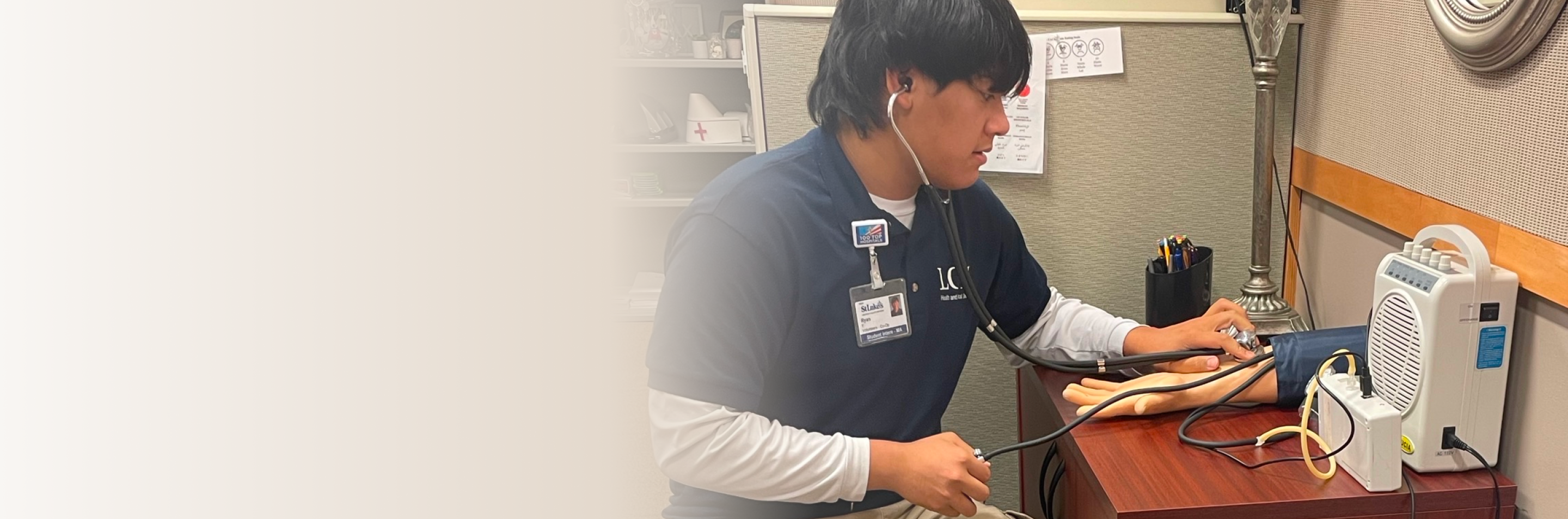 Student practicing taking blood pressure on medical manikin arm