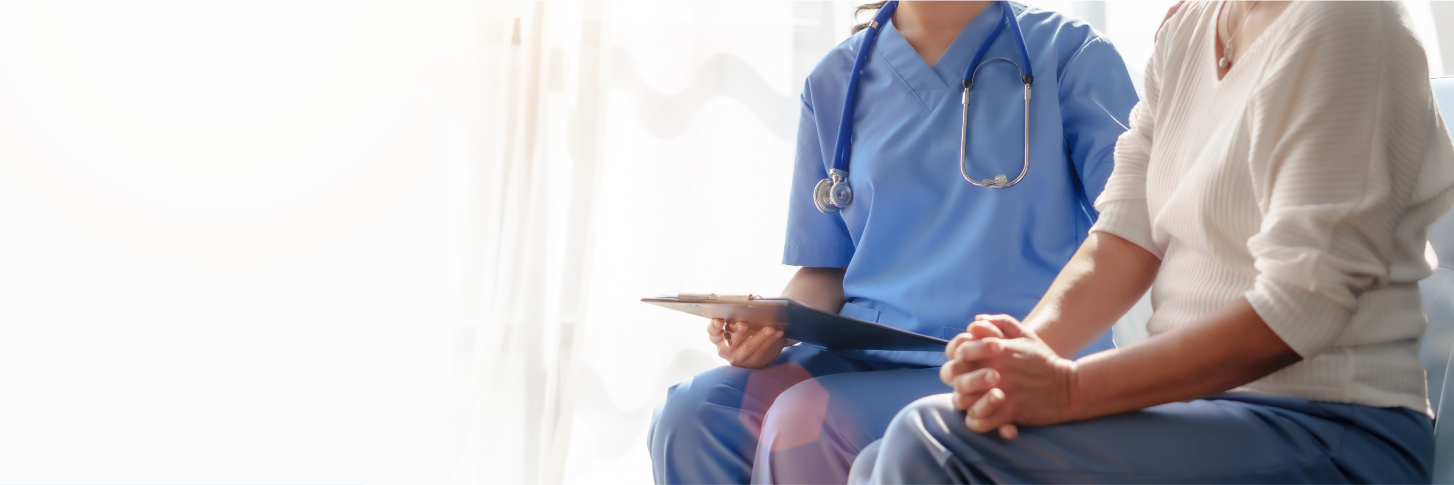 Female medial individual with a clipboard next to a patient