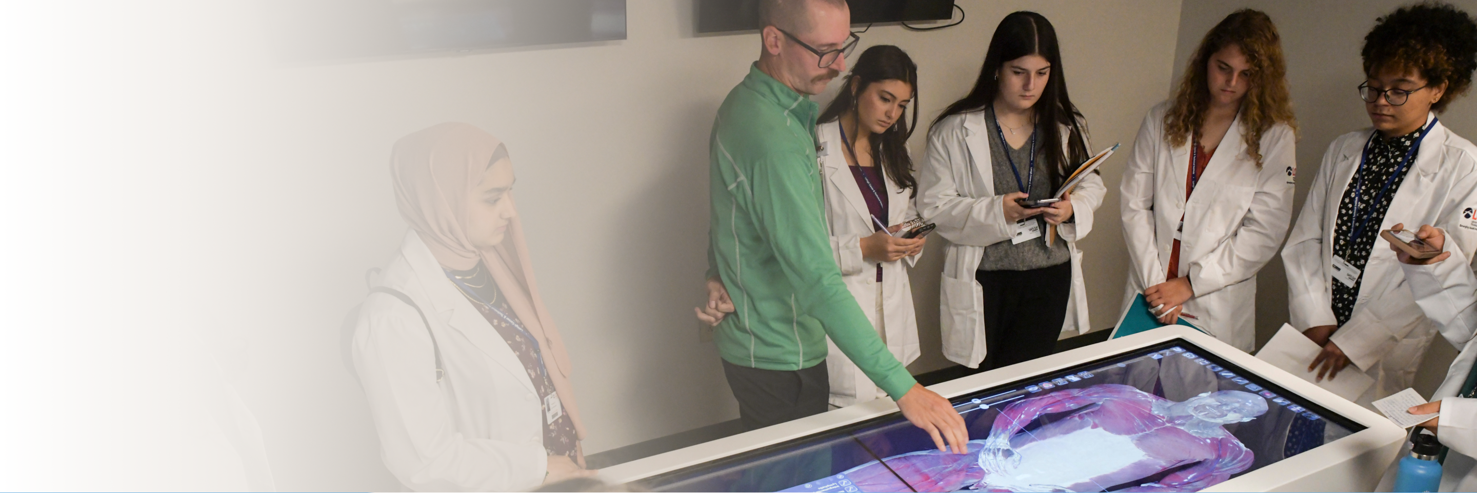 A group of students gathered around a learning desk with instructor